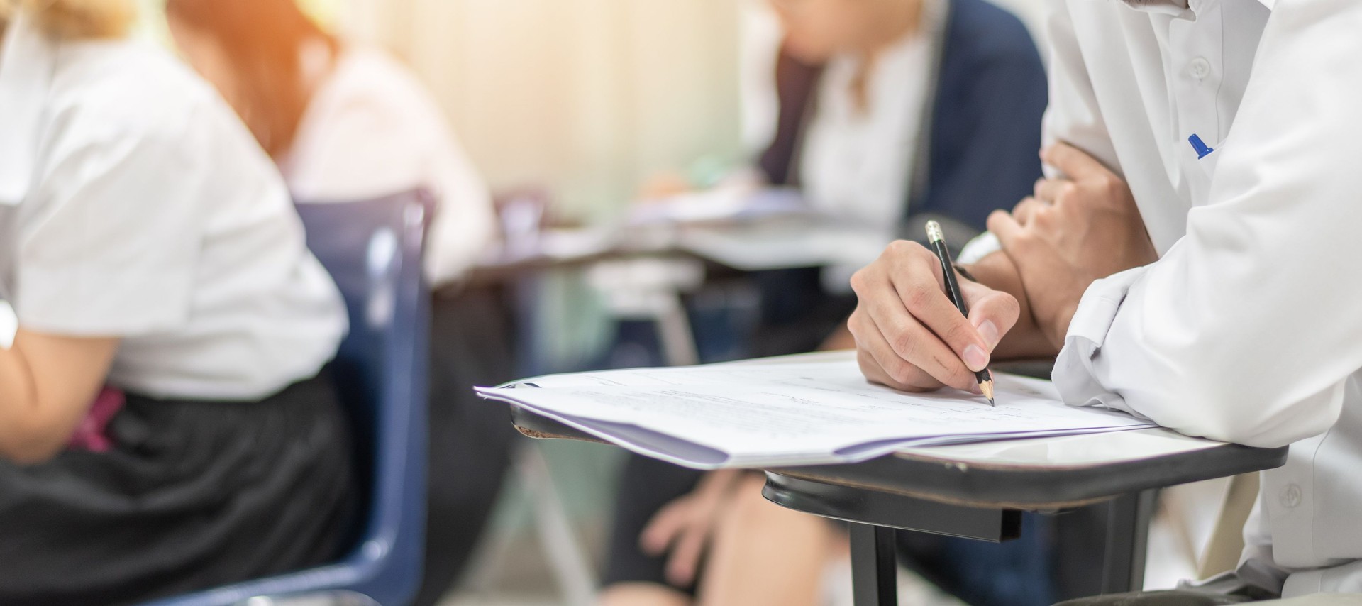 School exam student's taking educational test, admission test, thinking hard, writing answer in university classroom, education and world literacy day concept
