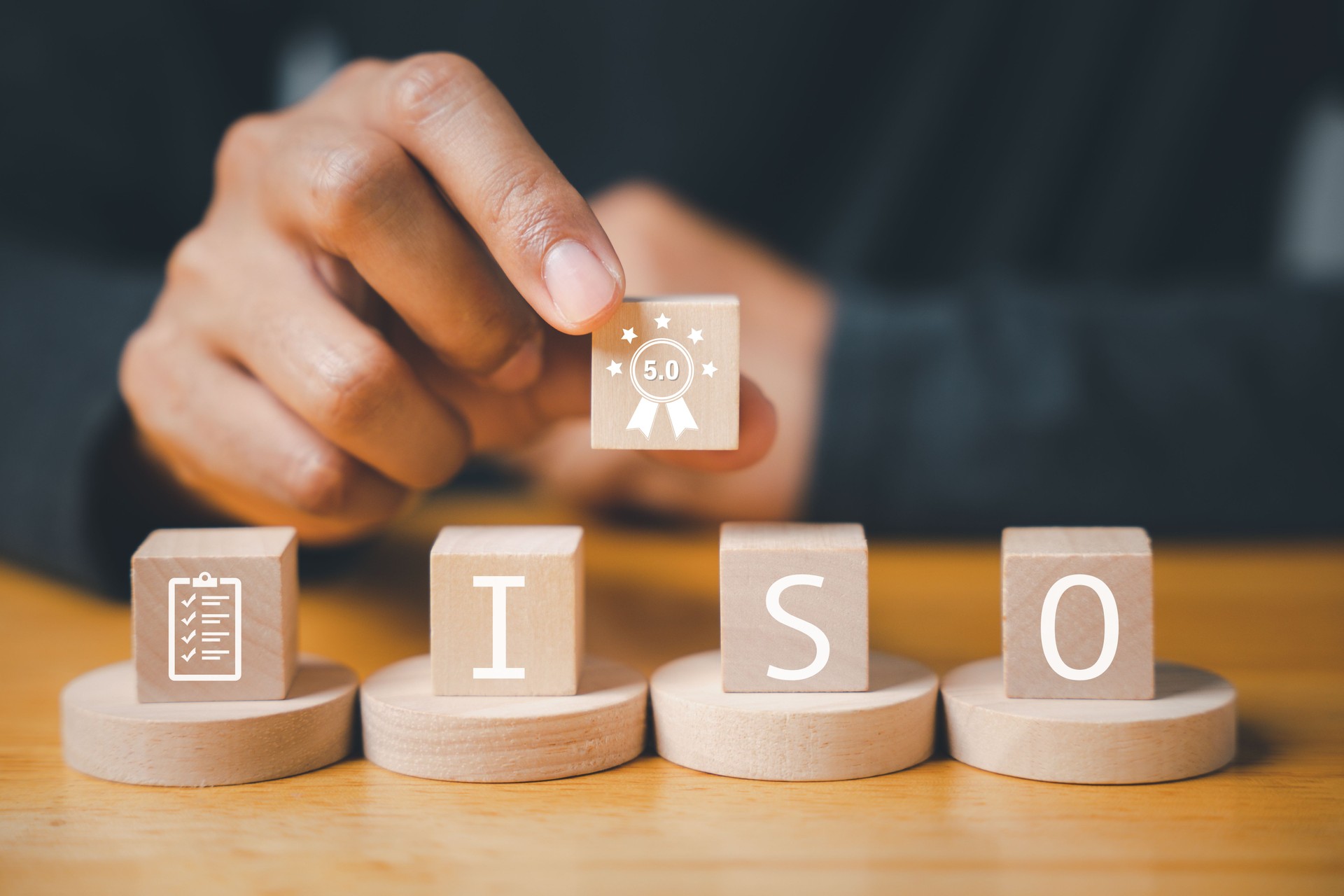 Businessman's finger pressing on ISO wooden cubes